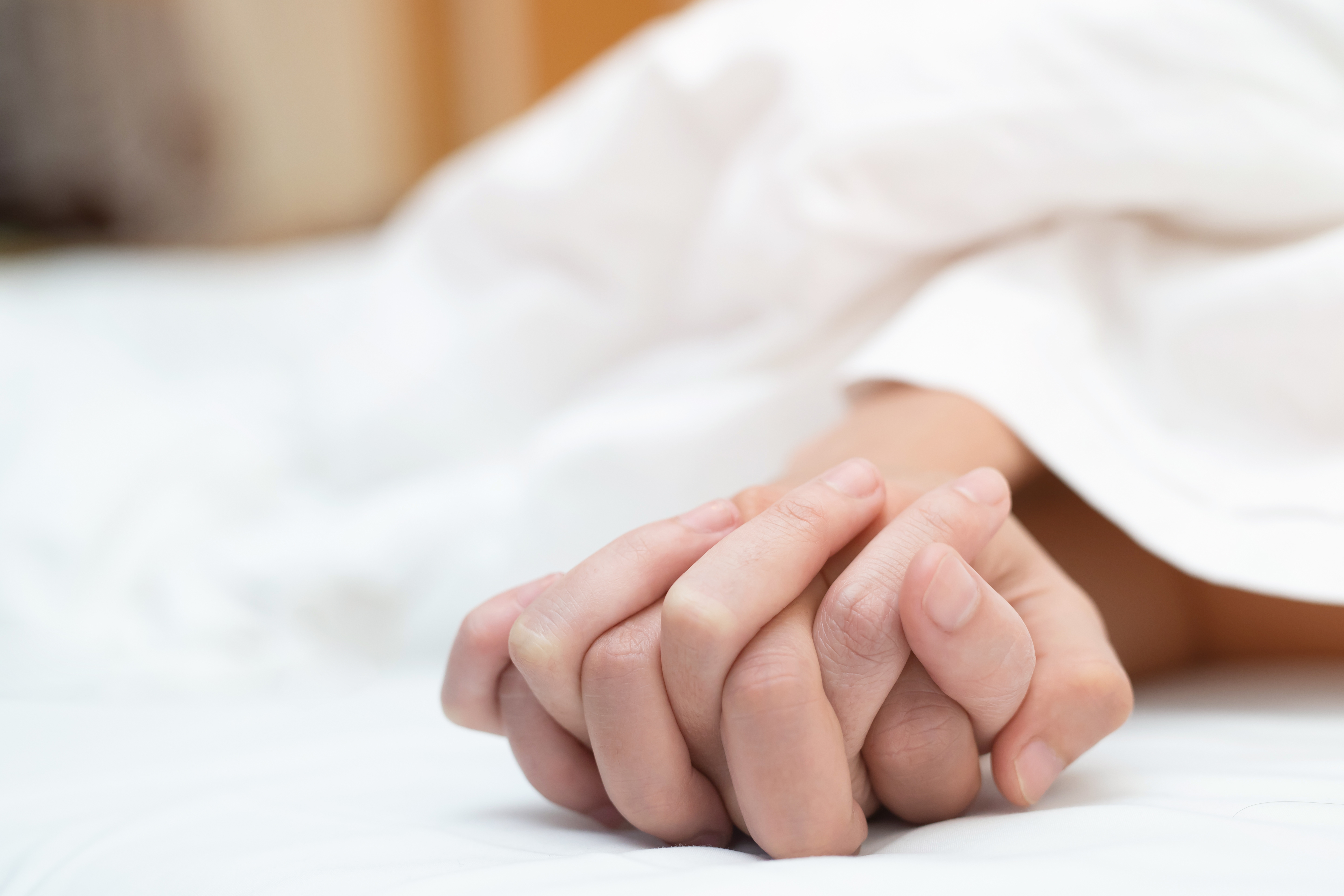 A couple enjoying a sexy moment together holding hands in bed - thedatingdivascom.bigscoots-staging.com A man and woman holding hands during sex | The Dating Divas