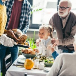 Little girl and grandpa looking at parents bringing in turkey | Date Your Spouse