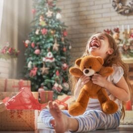 Little girl opening Christmas gift, teddy bear | Date Your Spouse