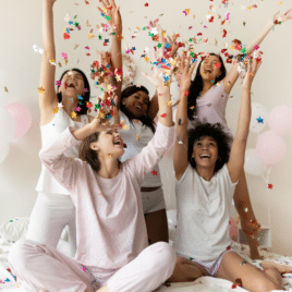 Women celebrating at bridal shower throwing confetti in air | Date Your Spouse