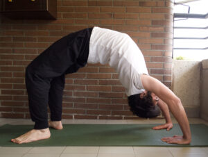 A husband practicing the bridge pose to help improve his sex life - dateyourspouse.com A man stretching at home for a sex workout date | The Dating Divas
