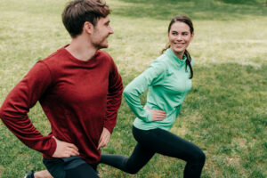 A happy couple doing The Sexercise Date together - dateyourspouse.com A man and women doing tandem stationary lunges for sex workout date | The Dating Divas