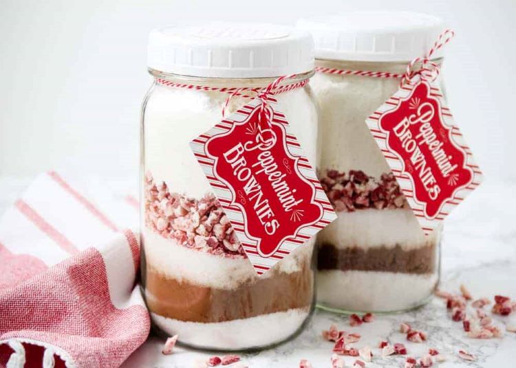 DIY peppermint brownie mix inside of two glass jars with labels on the front - dateyourspouse.com Glass mason jars filled with homemade peppermint brownie mix | The Dating Divas