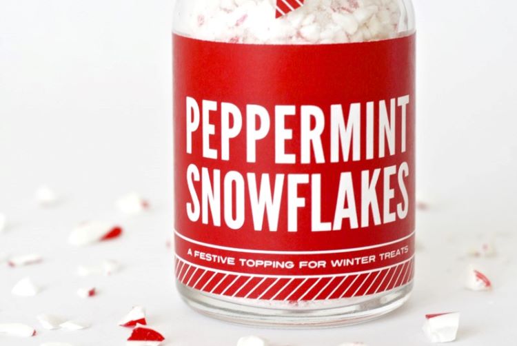 Crushed candy canes inside a glass jar that's decorated with a Christmas label - dateyourspouse.com A jar of small candy cane pieces that are called Peppermint Snowflakes | The Dating Divas