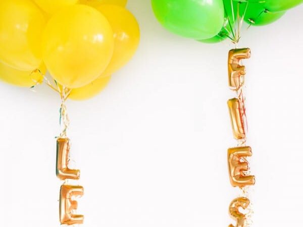 Mini lettered balloons attached to the strings of balloon clusters at a birthday party | The Dating Divas