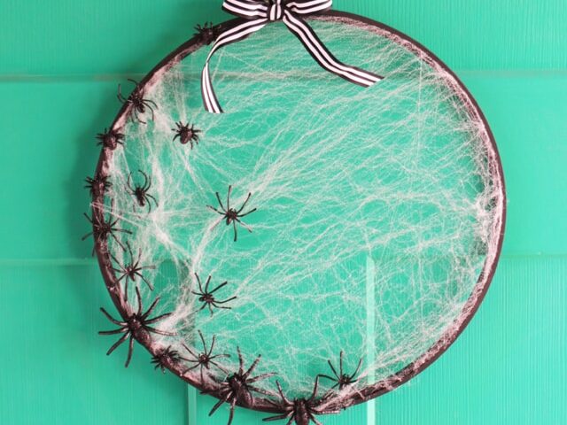 Make DIY Halloween decorations using an embroidery hoop, fake spiders, and fake spiderwebs. | The Dating Divas