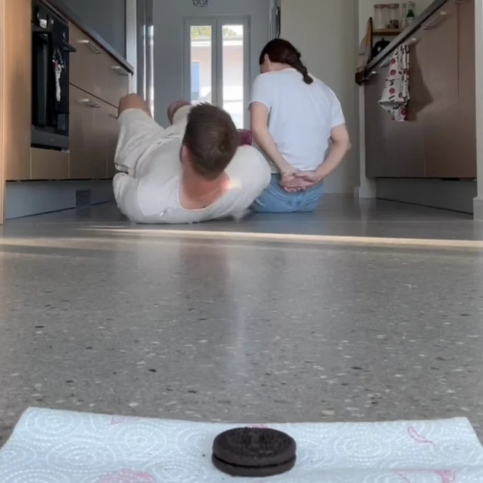 Husband and wife playing the funny no arms eat the cookie couples challenge